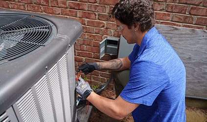 Technician installing outdoor AC unit Technician installing outdoor AC unit