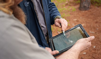 Technician reviewing estimate on tablet with customer
